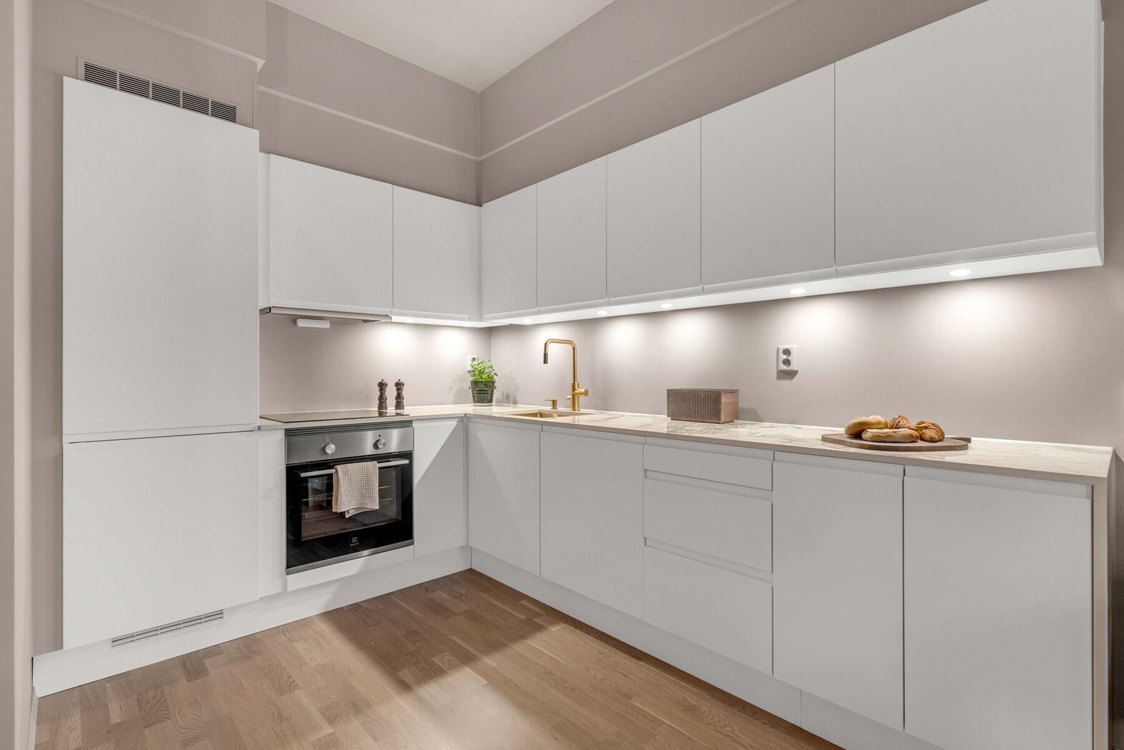 Glatte, moderne fronter kombineres med en benkeplate i stein, med underlimt oppvaskkum og stilrent ettgreps blandebatteri. Galleribilde