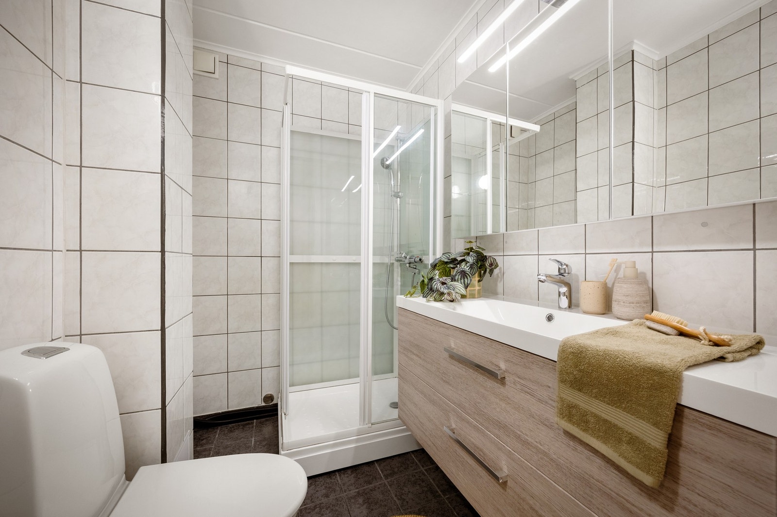 Badet er innredet med keramiske fliser på gulv og vegger, og det er malt betong i himling Galleribilde