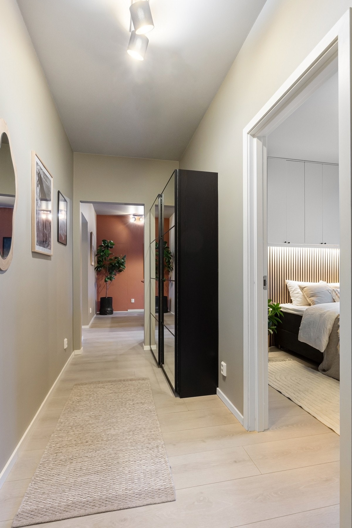 Lys og innbydende entré med gjennomgående overflater og medfølgende skyvedørsgarderobe langs vegg. Galleribilde