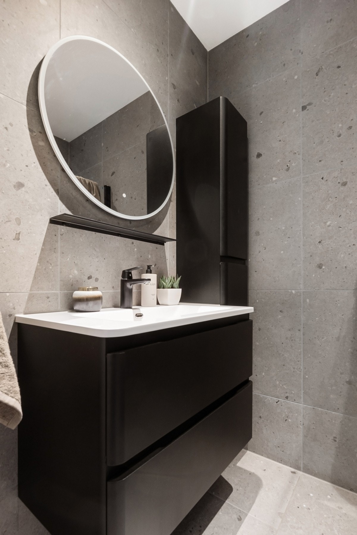 Stilrent baderom med vegghengt servantskap, heldekkende servant og speil med integrert belysning. Galleribilde