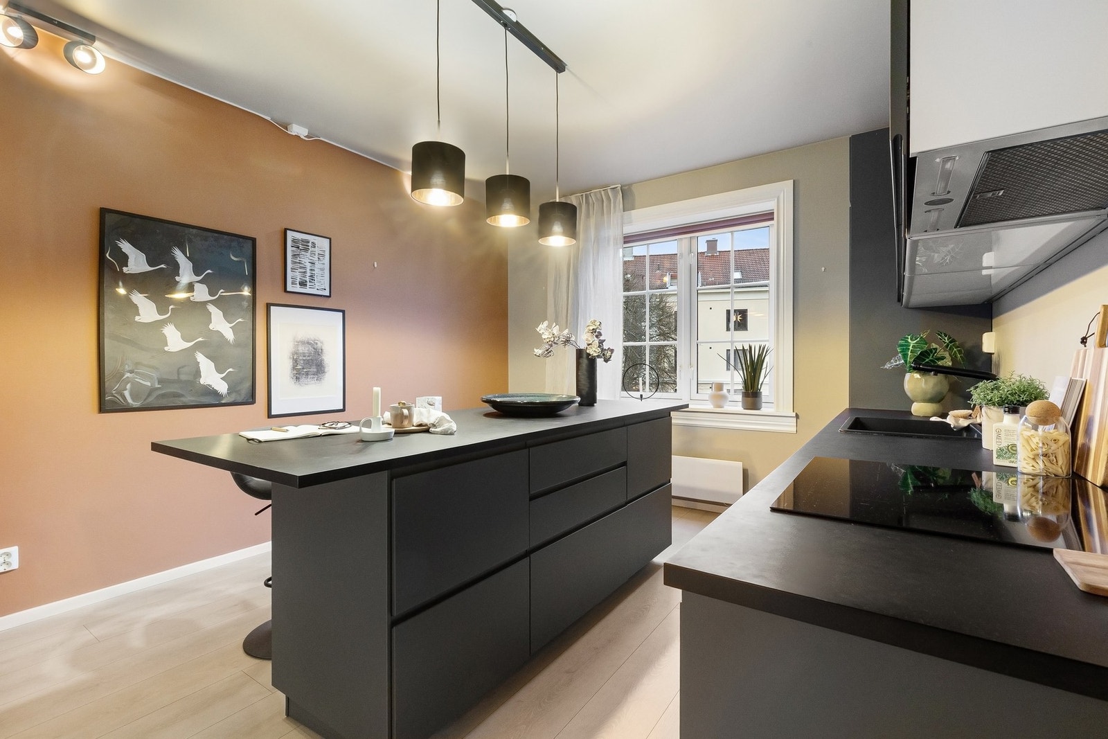 Harmonisk fargevalg på kjøkkeninnredning og veggflater, med vindu mot rolig bakgård som gir godt lysinnslipp. Galleribilde