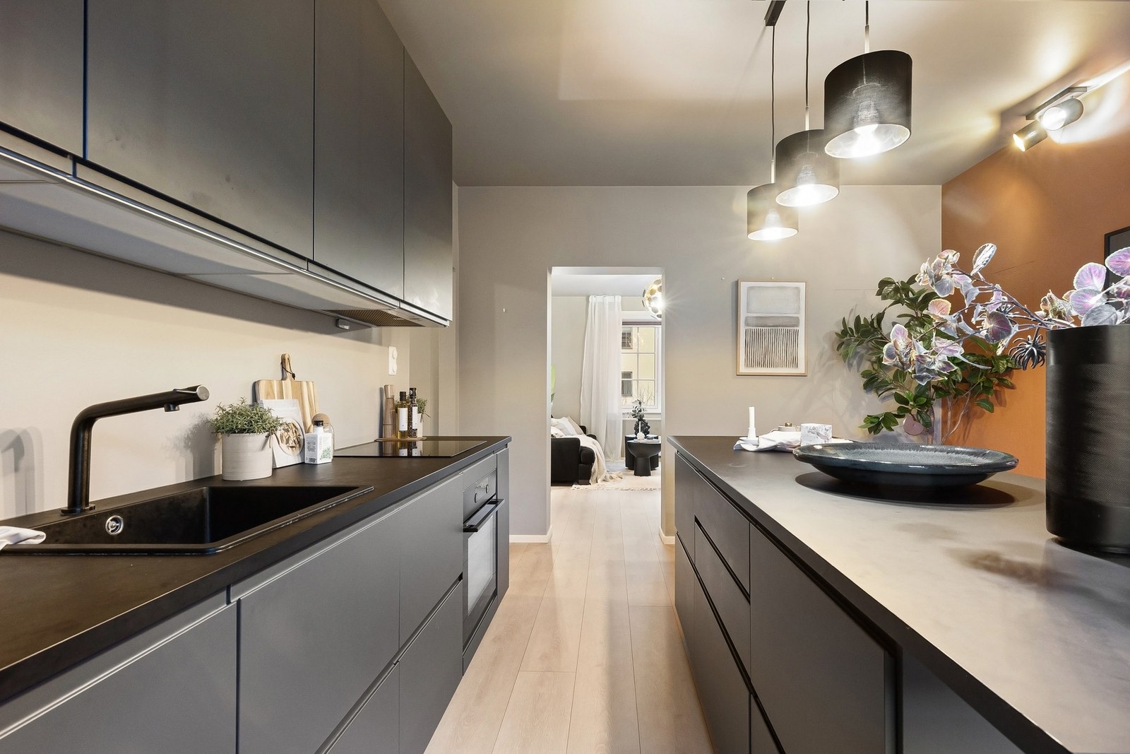 Delvis åpen løsning mellom kjøkken og stue skaper en sosial og sammenhengende oppholdssone. Galleribilde