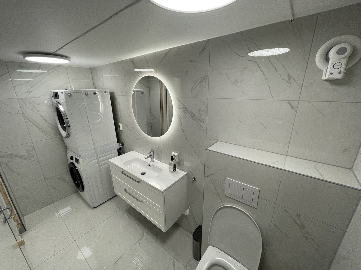 Badet er fullt møblert med vaskemaskin og tørketrommel Galleribilde