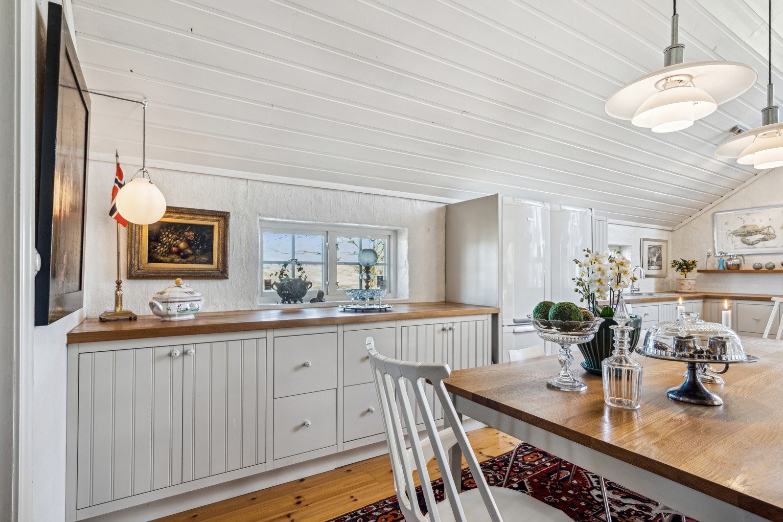 Innredningen har lyse, innenforliggende fronter, noen rillefronter og hyller, samt benkeplate i heltre med nedfelt vaskekum i stål. Galleribilde