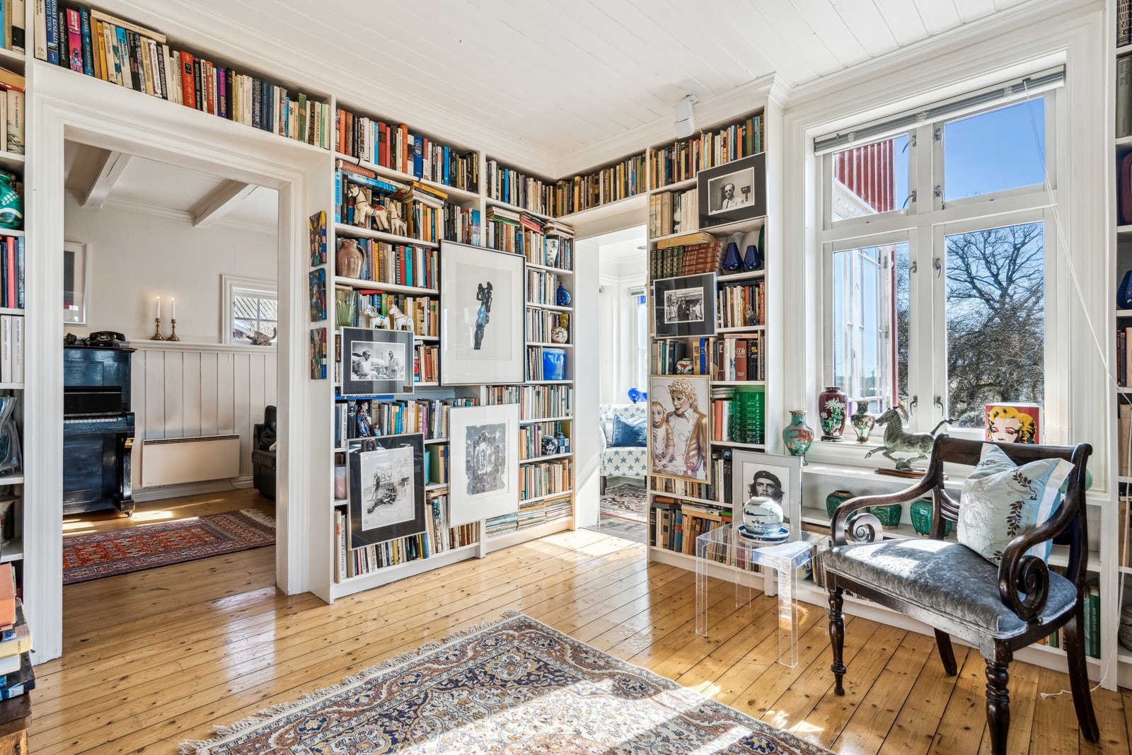 Den ene stuen har plassbygde bokhyller fra gulv til tak, utgang til terrassen og inngang til en sjarmerende, liten vinterhage Galleribilde