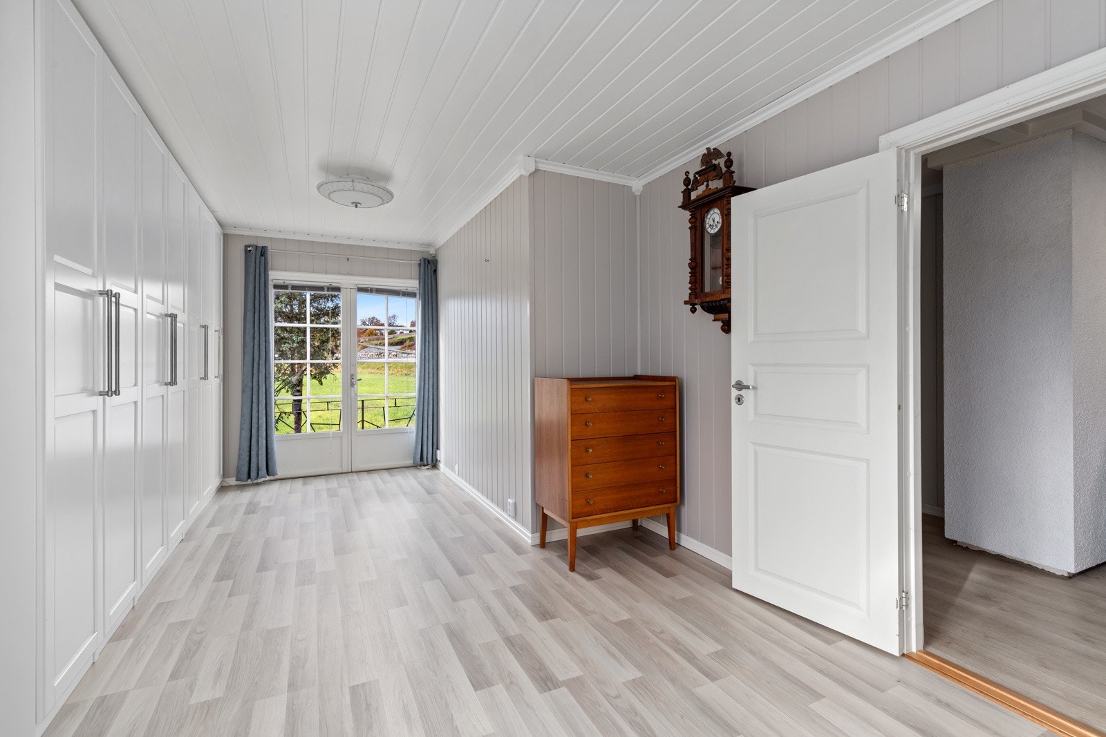 Her er det rikelig med plass til oppbevaring i garderobeskap med glatte fronter. Galleribilde