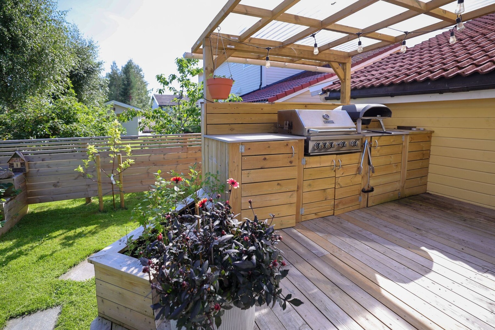 Pent opparbeidet uteområde med utekjøkken med takoverbygg. Galleribilde