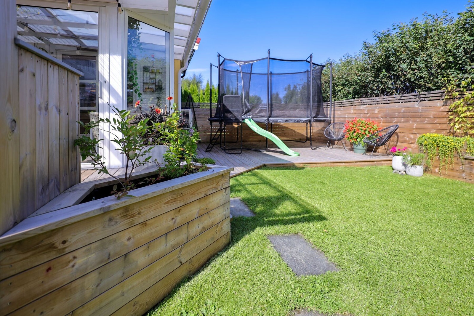 Solrik terrasse på baksiden av boligen. Her sitter man skjermet til fra naboene. Galleribilde