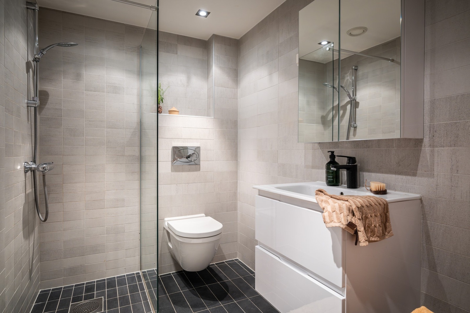 Flislagt bad/wc med varmekabler, mekanisk avtrekk og downlights. Galleribilde