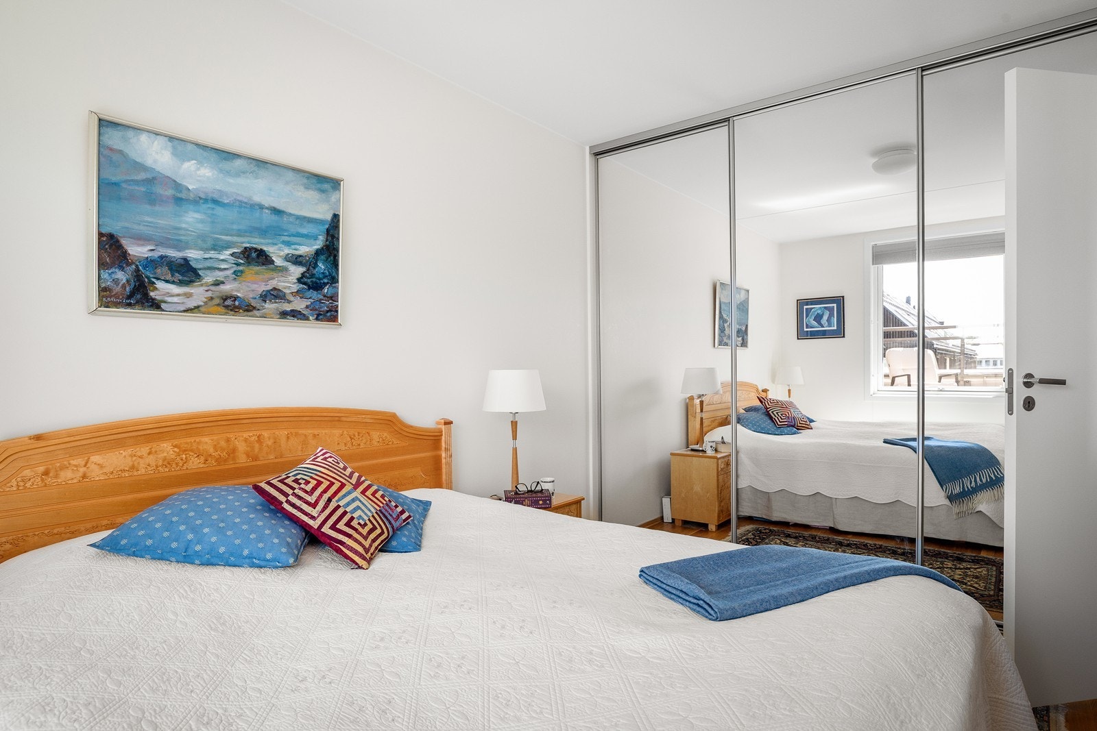 Her er det en skyvedørsgarderobe med speilfronter som gir rikelig med oppbevaringsplass og bidrar til et lyst og ryddig uttrykk. Galleribilde