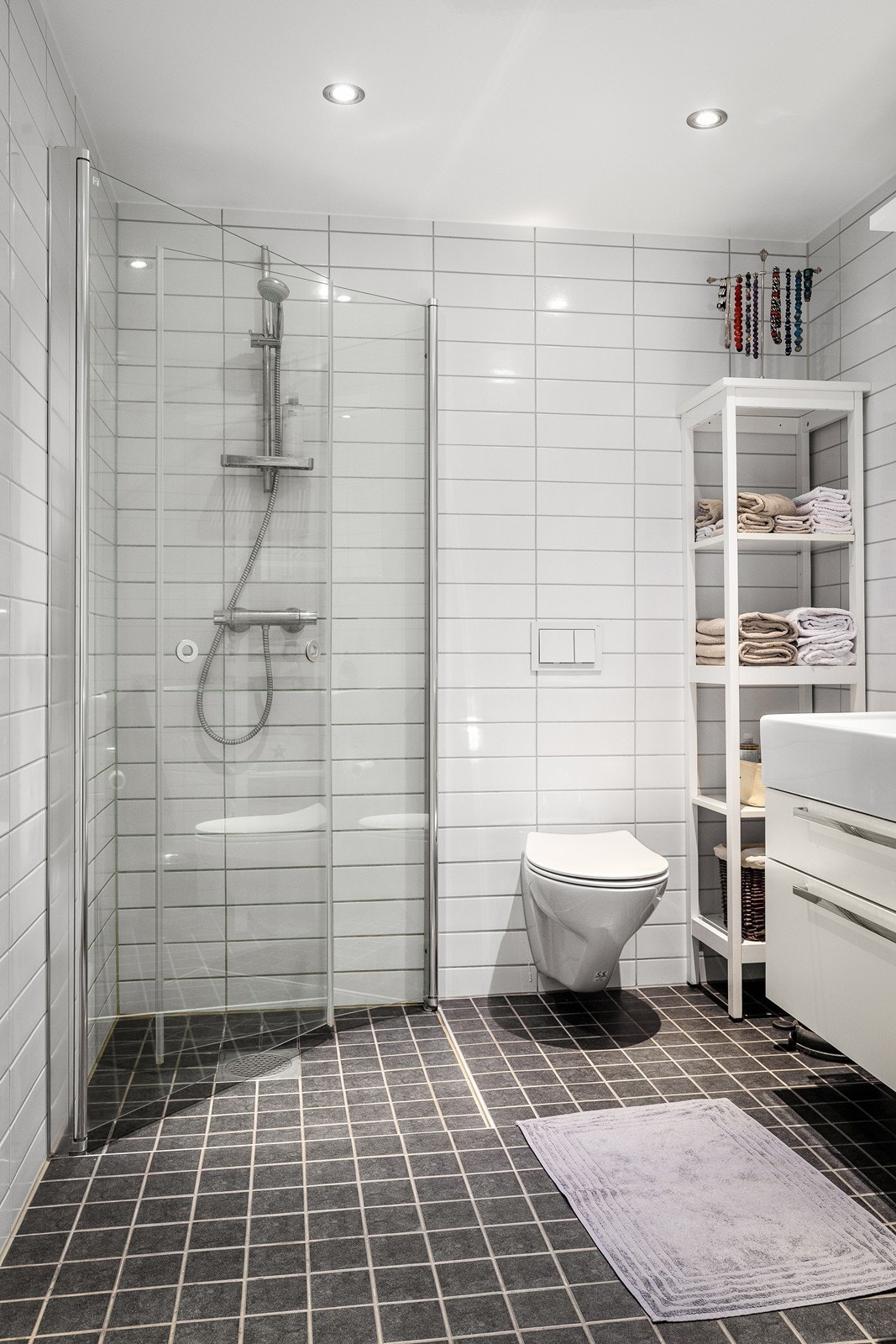 Badet er utstyrt med servant med servantskap, veggmontert toalett og dusjløsning med innfellbare glassdører. Galleribilde