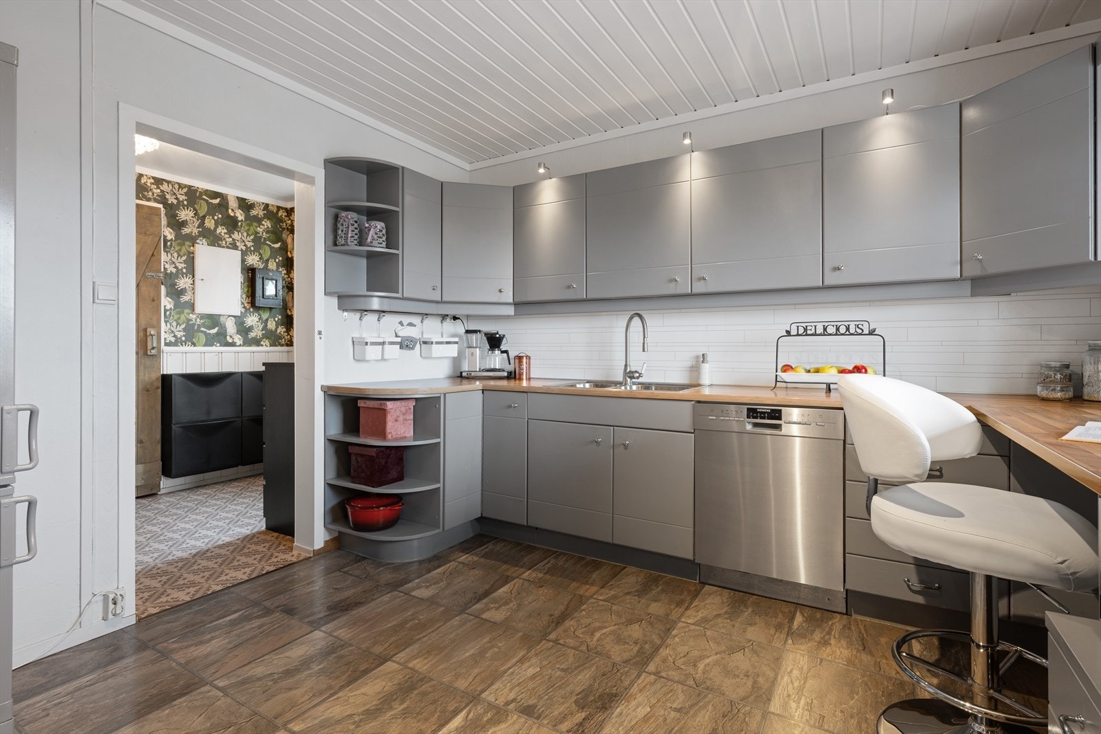 Kjøkkenet har pen Huseby innredning med malte dører og laminat benkeplate Galleribilde