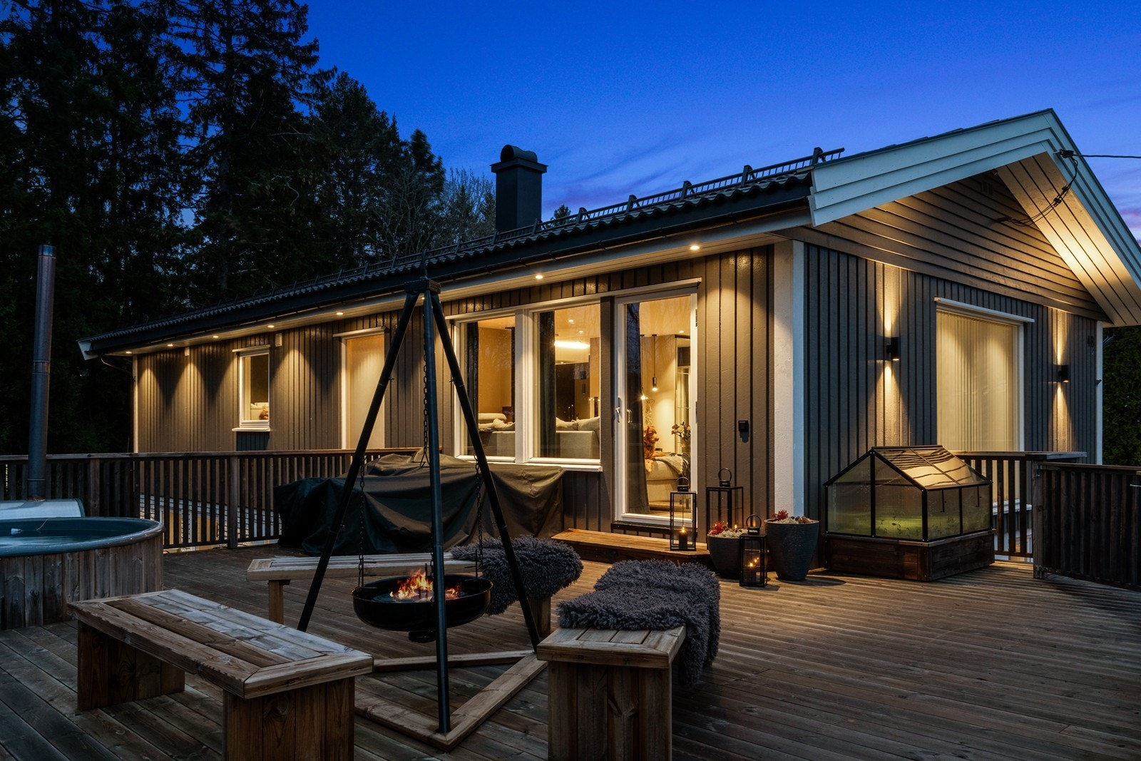 Terrassen har en solid bordkledning og gir tilgang til uteområdet med peis og sitteplasser. Galleribilde