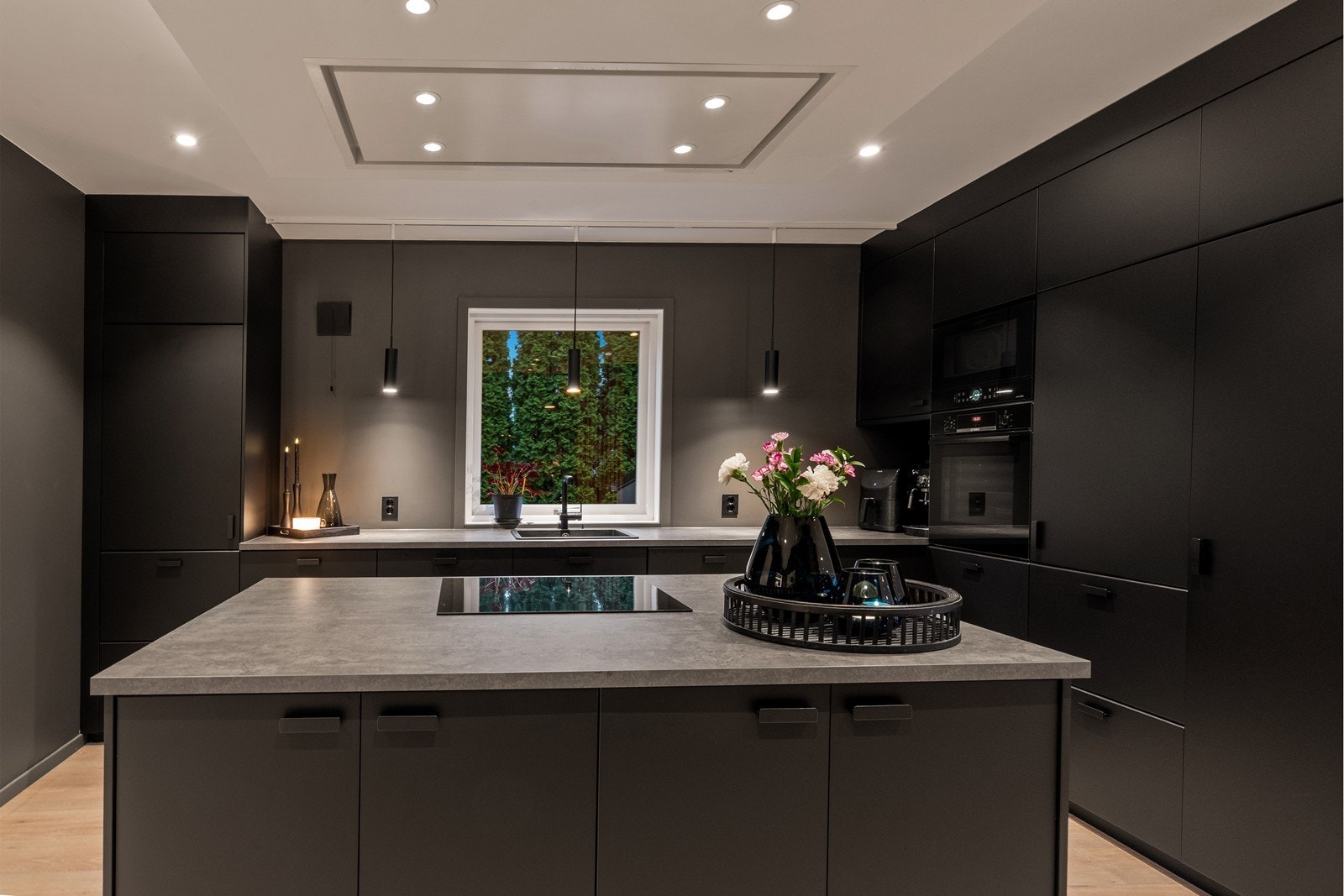 Benkeplate av laminat og kjøkkenventilator med avtrekk ut sikrer effektiv matlaging. Galleribilde