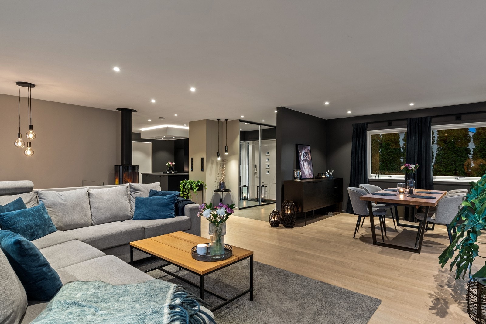 Pen stue med lys parkett og store vindusflater gir stuen et romslig preg. Galleribilde