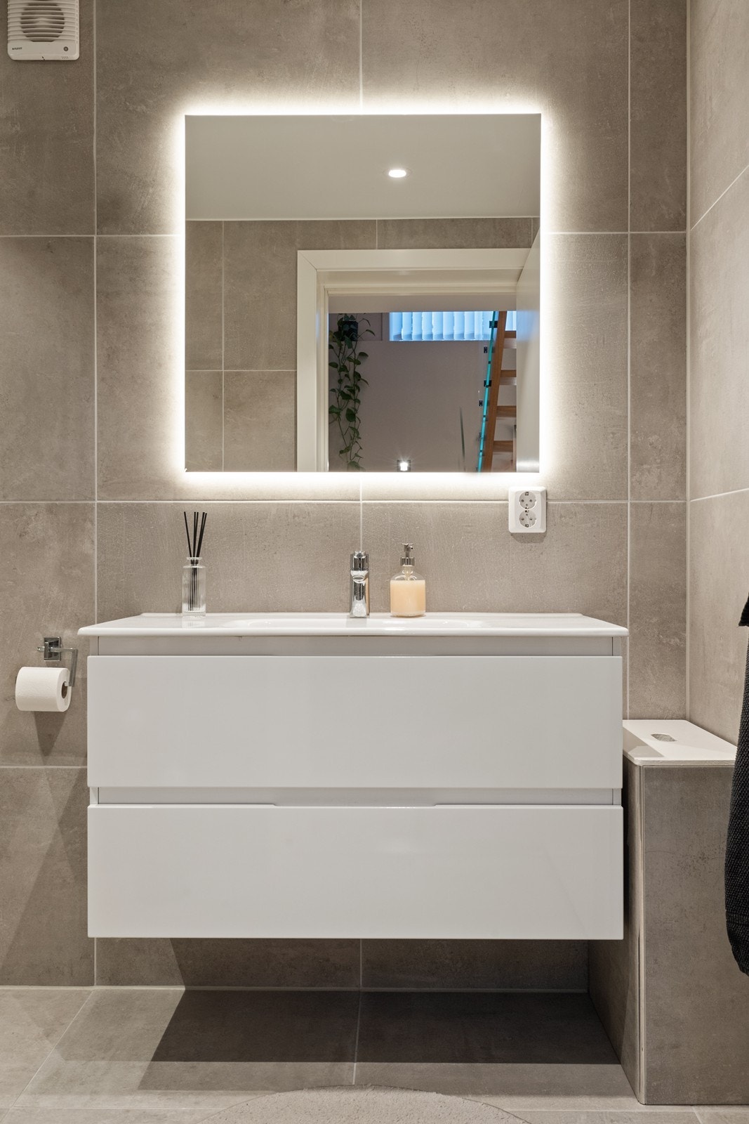 Speil med integrert belysning og glatt innredning gir funksjonell baderomsløsning. Galleribilde