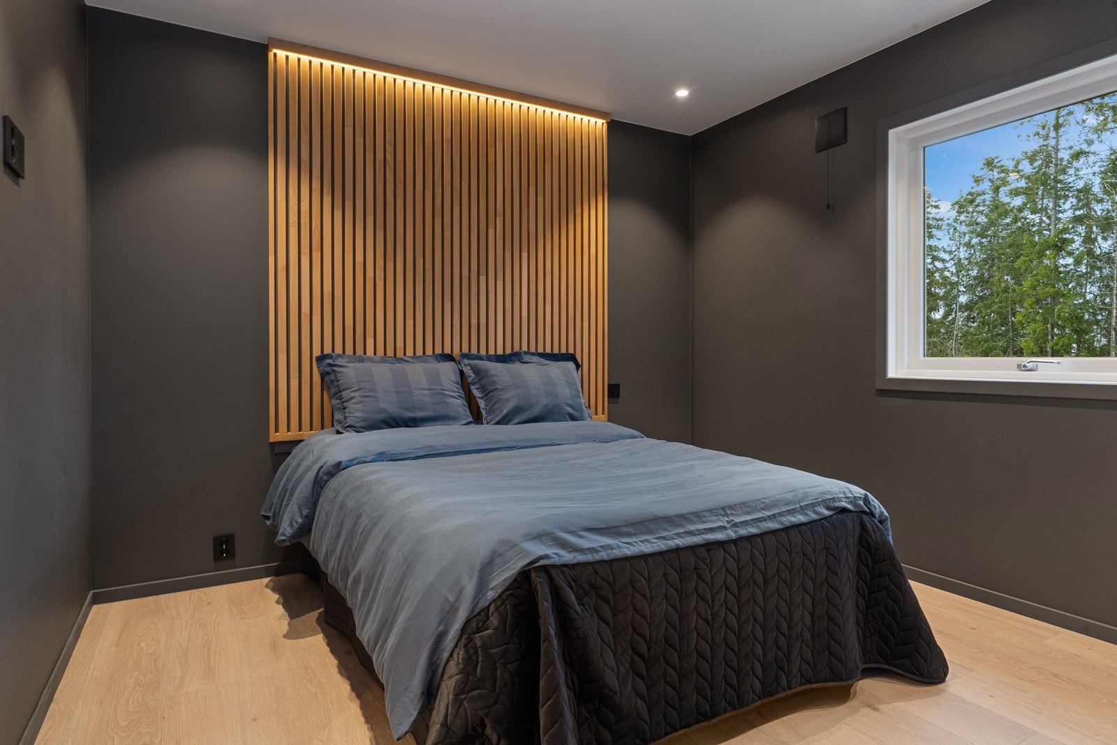 Lekkert soverom med laminatgulv og elegant veggpanel. Galleribilde