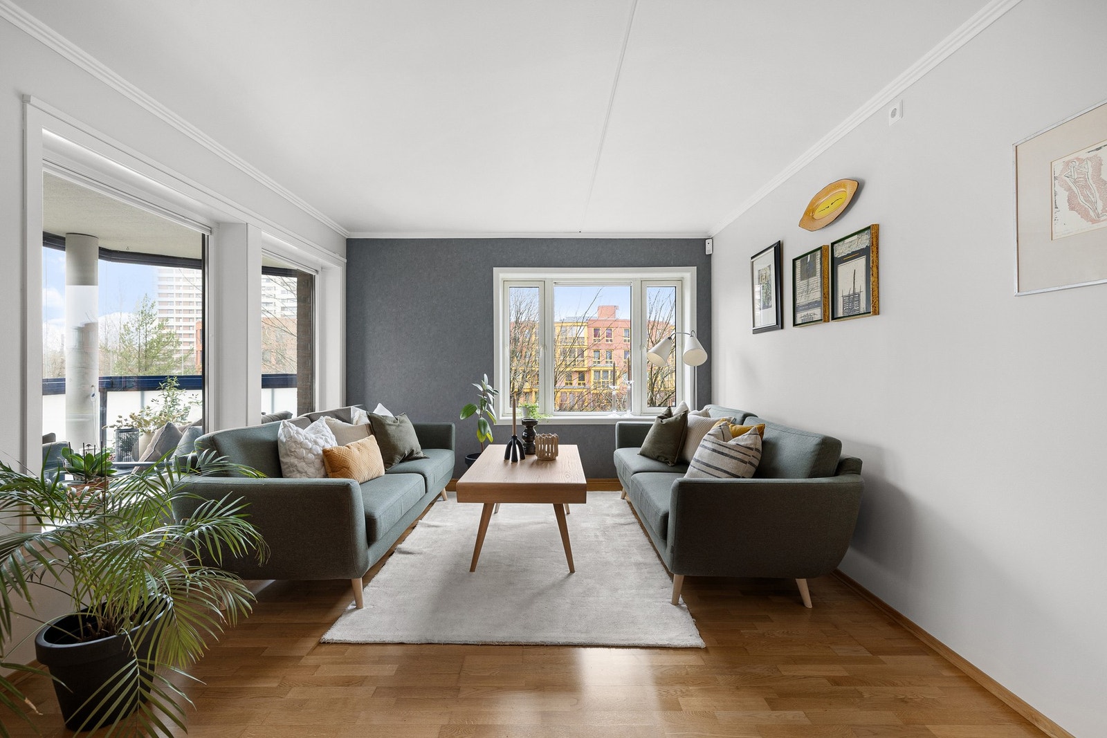 Stuen har en glassdør til balkongen og store vinduer som gir masse naturlig lys Galleribilde