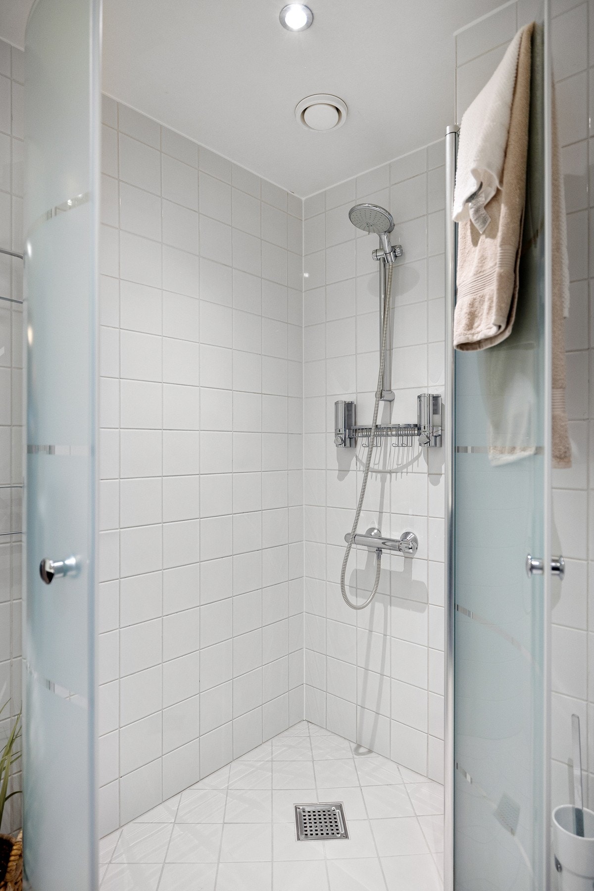 Rommet har servant, veggmontert toalett, dusjhjørne med to svingbare dører og opplegg for vaskemaskin Galleribilde