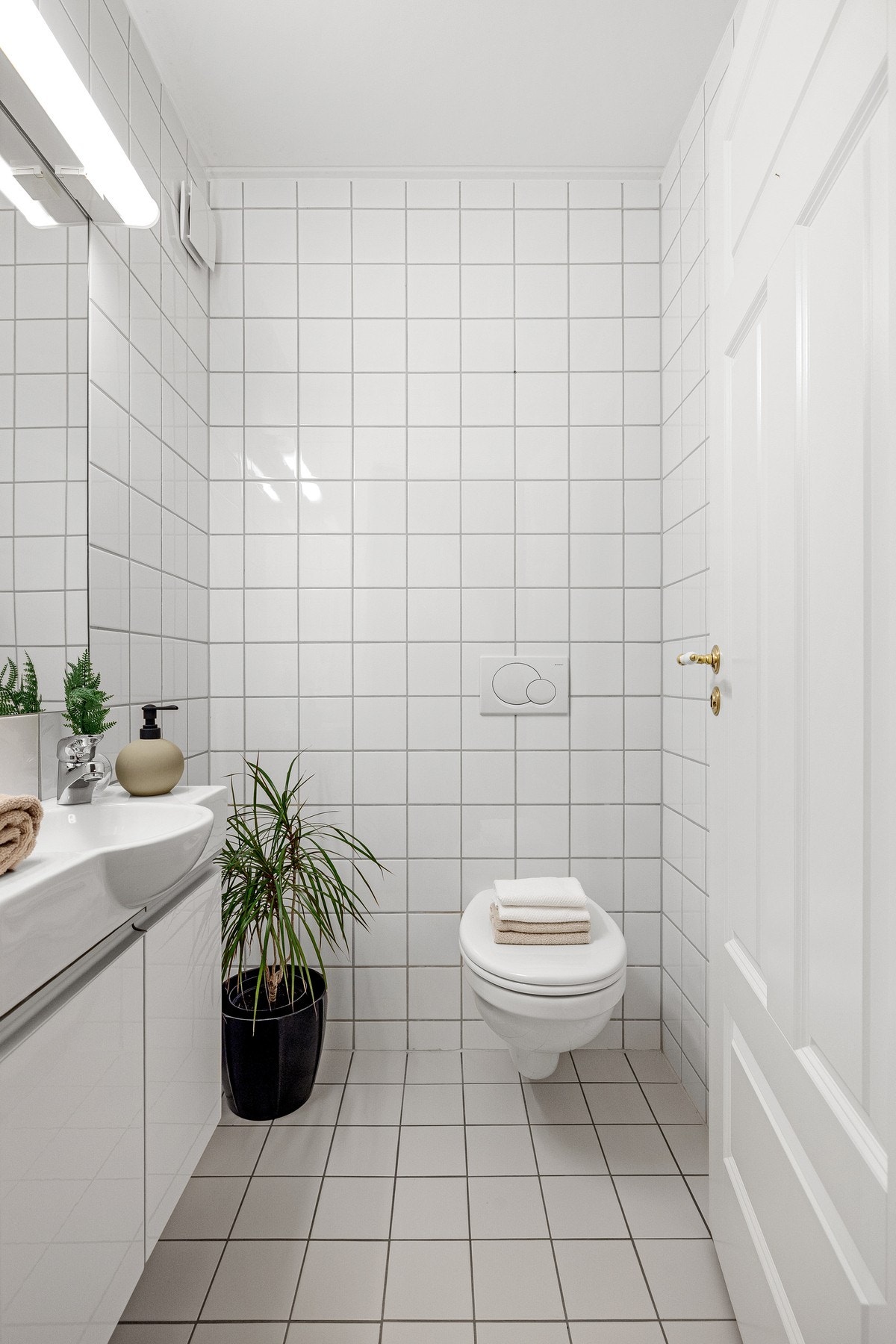 Toalettrommet har vegghengt klosett med innebygget sisterne og innredning med slette fronter Galleribilde