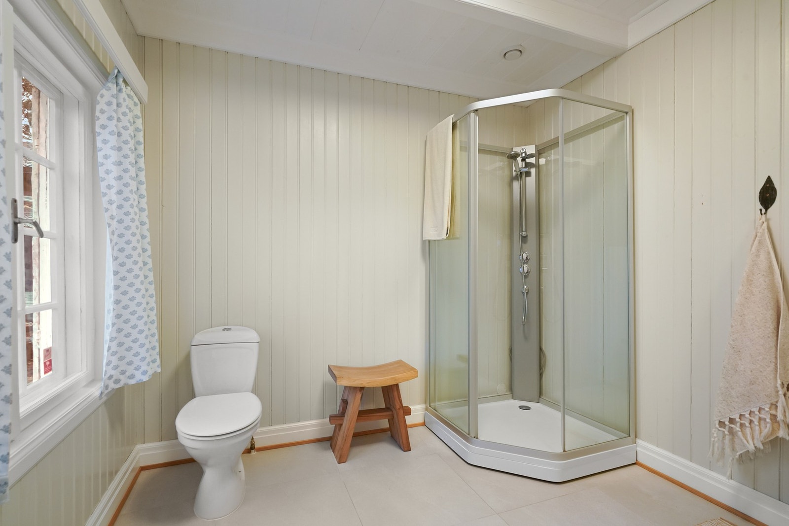 Baderommet ble pusset opp i 2021 med flislagt gulv og malt panel på veggene. Galleribilde