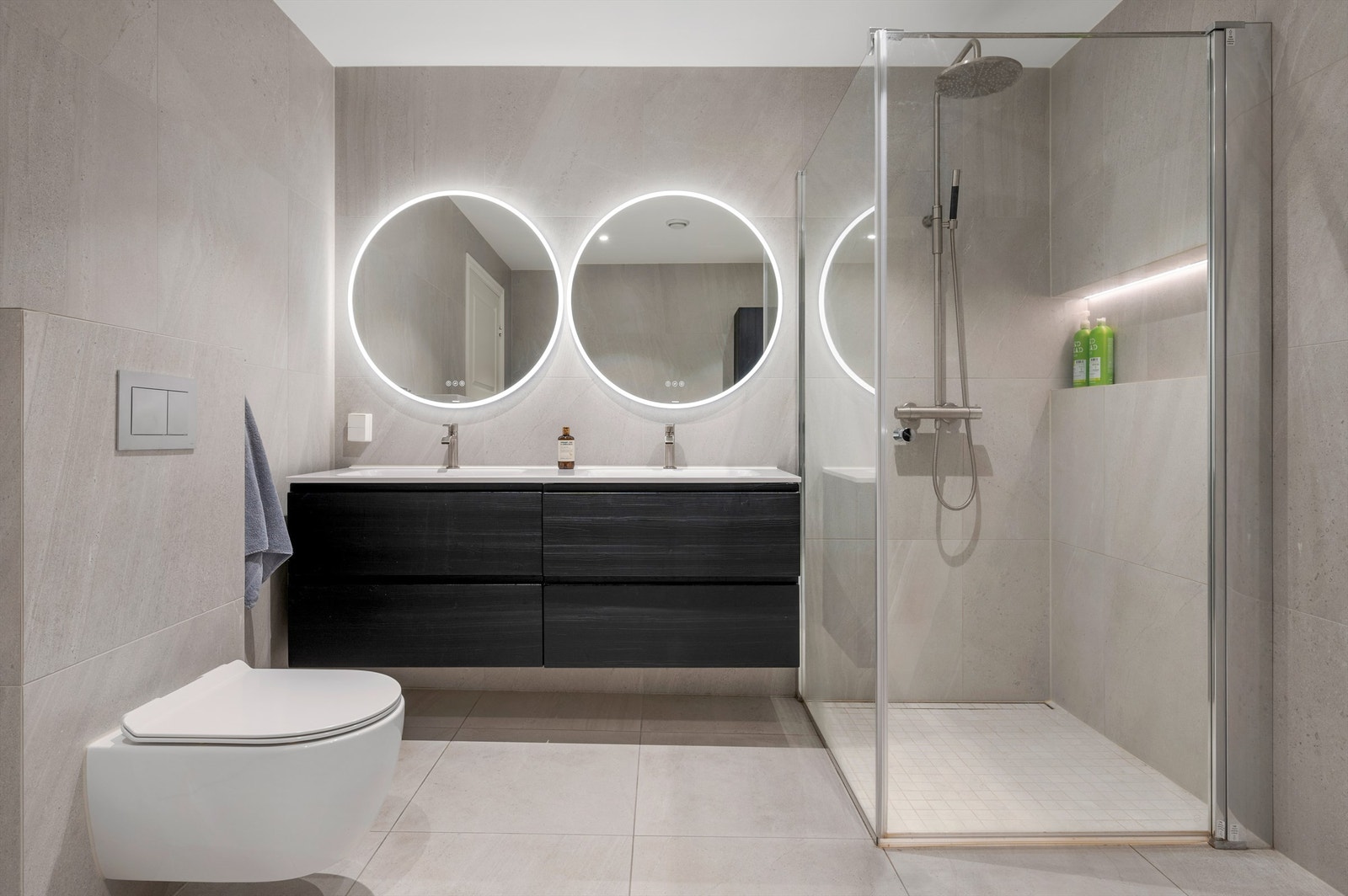 Pent flislagt bad på 8,5 kvm med gulvvarme og downlights i himling. Videre er badet innredet med dobbeltservant med speil og lys, dusjhjørne med regndusj og vegghengt toalett. Galleribilde