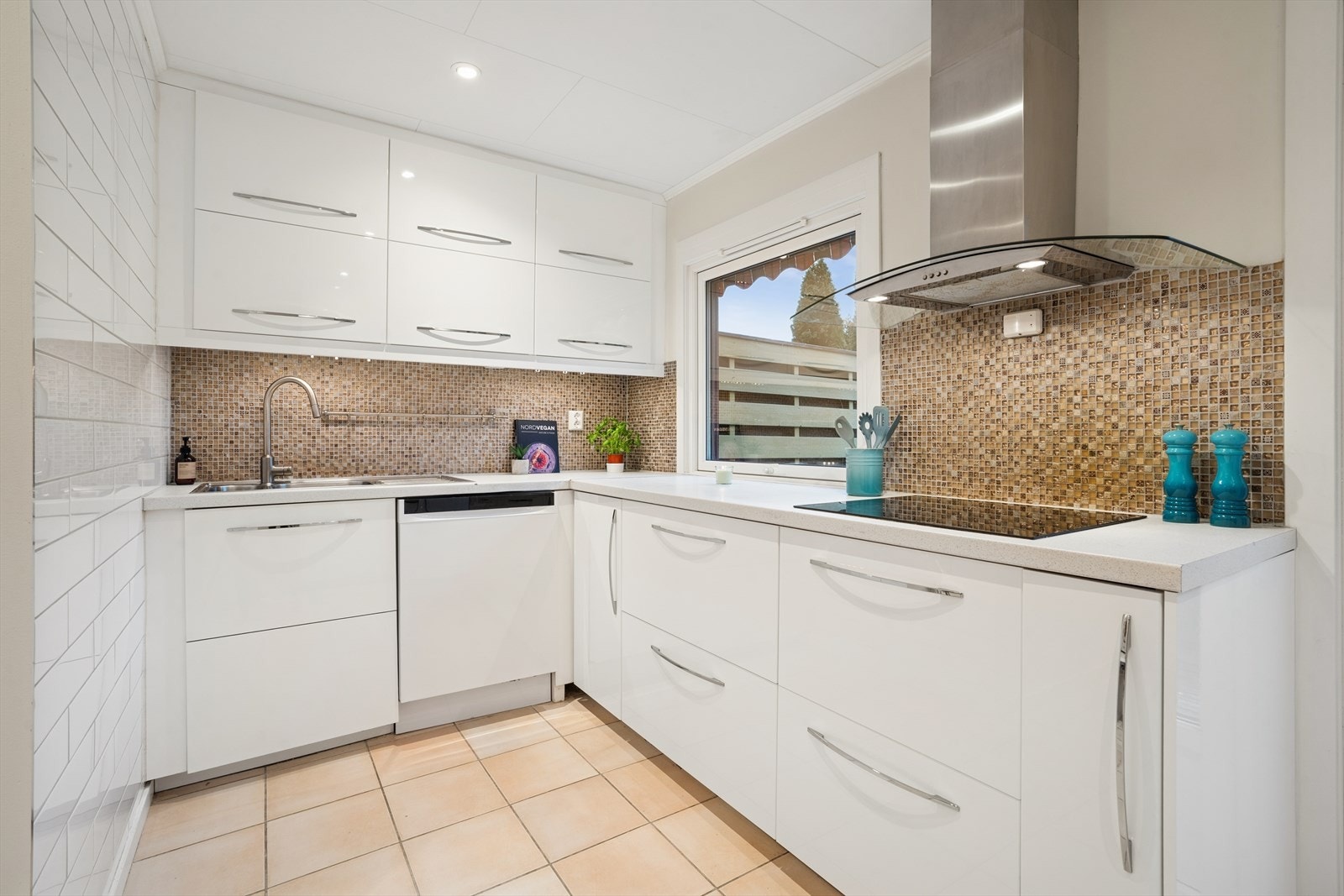 Gulvet har fliser med varmekabel, og veggene er malte, med mosaikkfliser mellom over- og underskap. Galleribilde