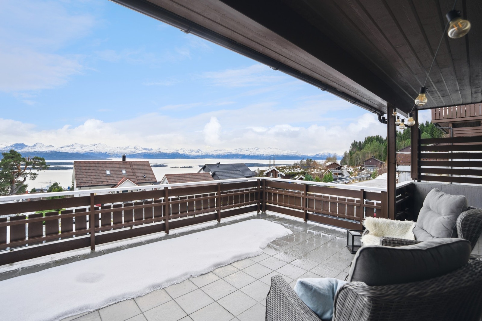 Verandaen har flislagt dekke og rekkverk i treverk med spiler. Galleribilde