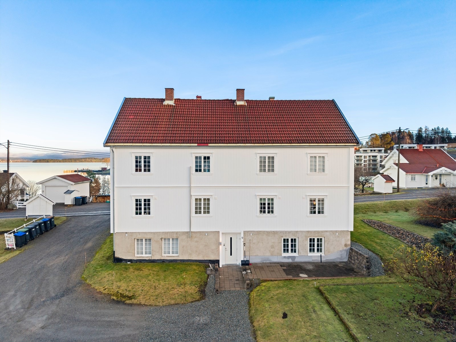 Fellesareal med plen og gruset gårdsplass/parkering. Galleribilde