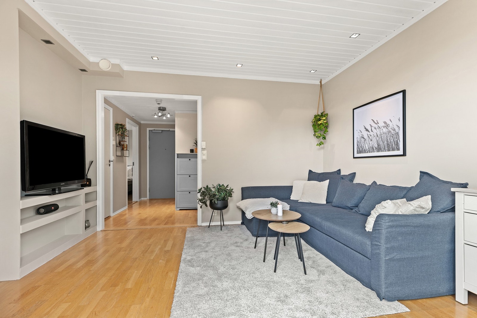 Stue har åpen adkomst fra entré med oppbevaringsløsninger Galleribilde