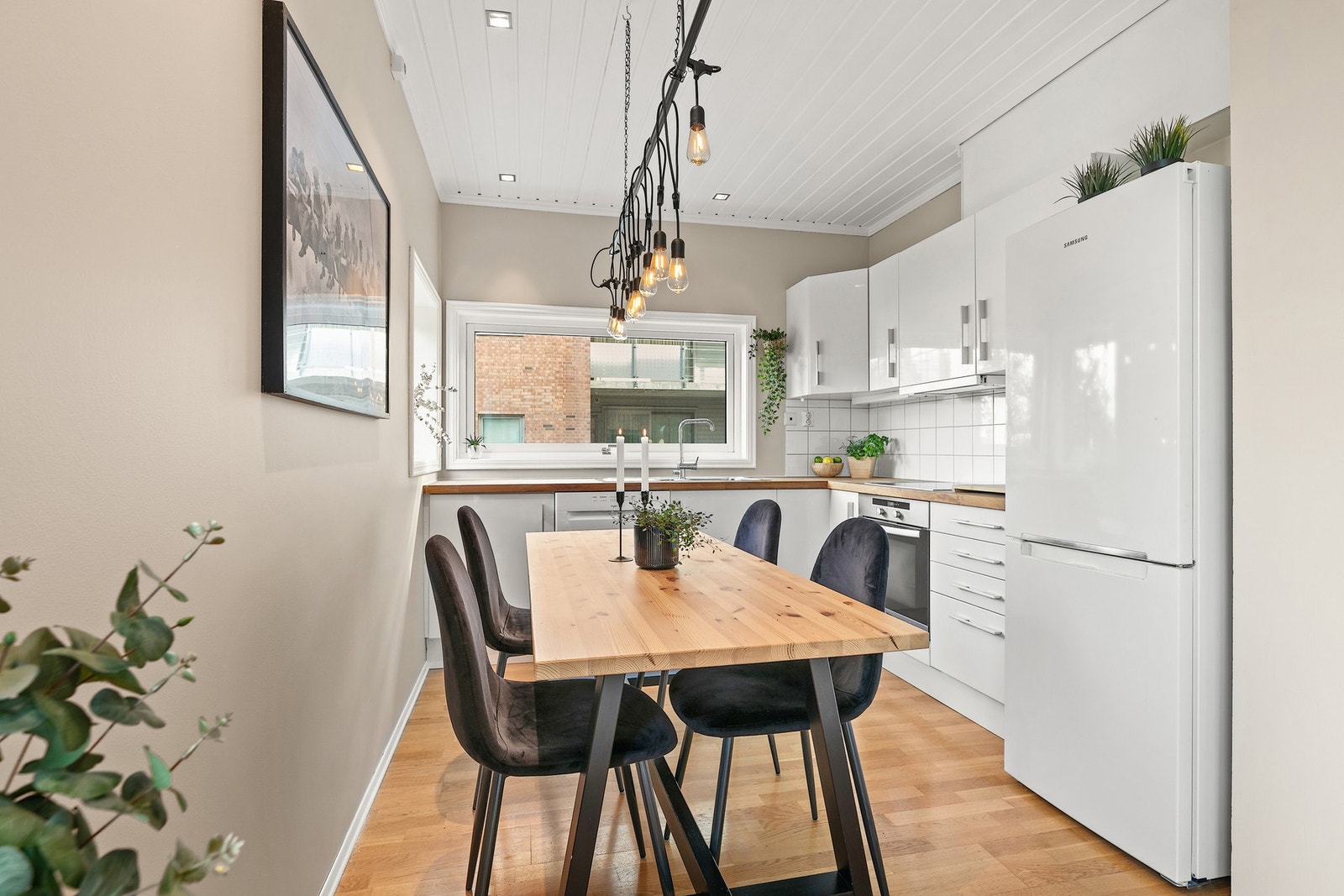 Kjøkkenet er utstyrt med en innredning med oppbevaring i overskap og benkeskap Galleribilde