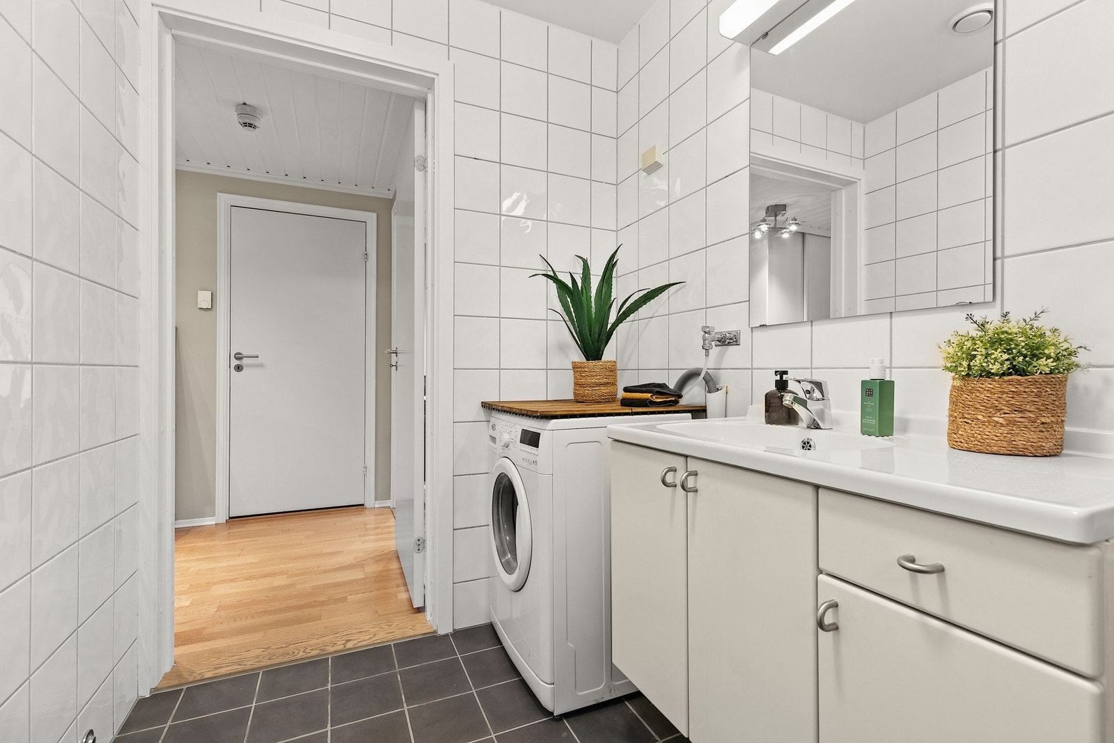 Det flislagte badet er utstyrt med opplegg for vaskemaskin og oppvarming via vannbåren varme i gulv Galleribilde