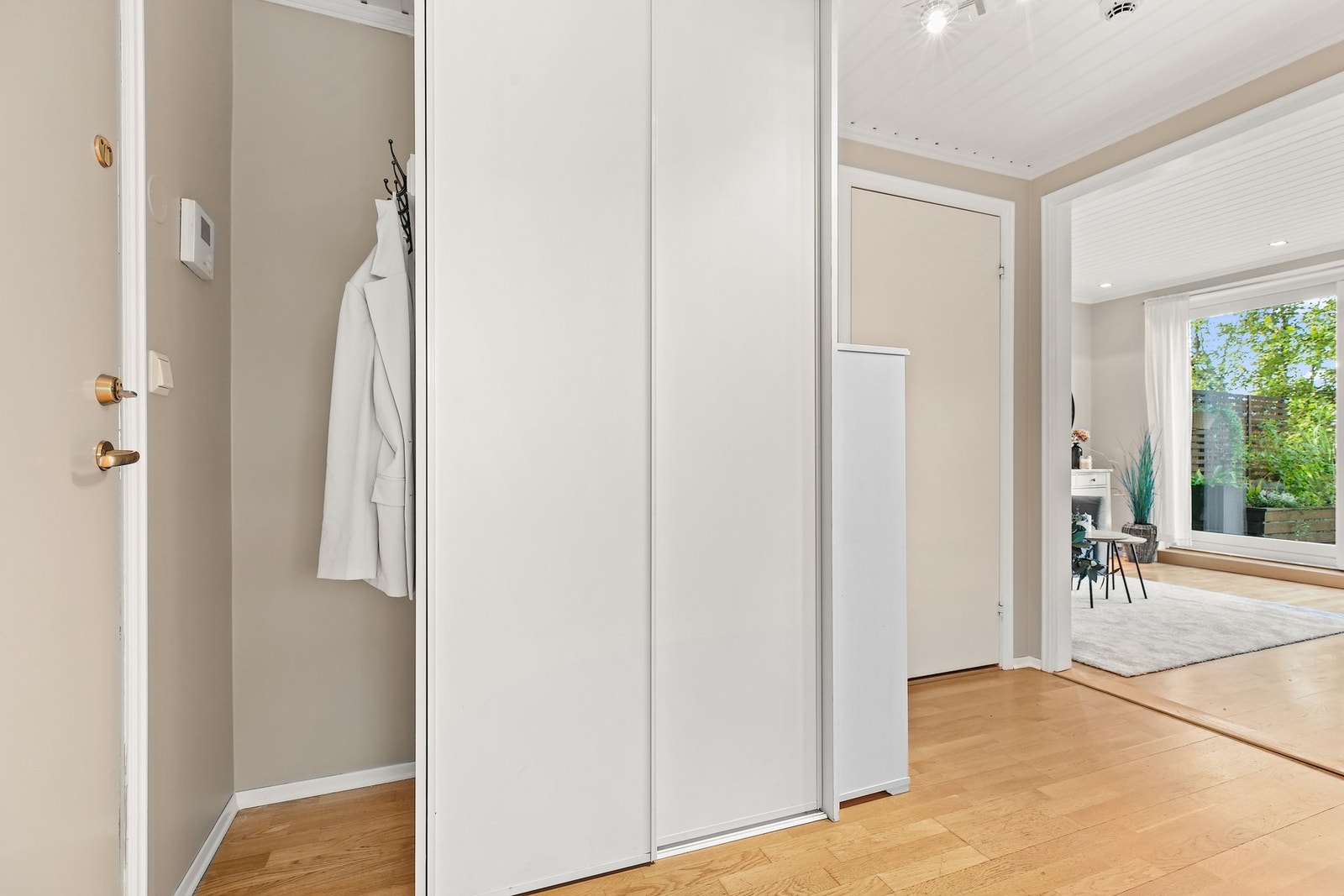 Entré med skyvedørsgarderobe har praktisk adkomst til en innvendig bod Galleribilde