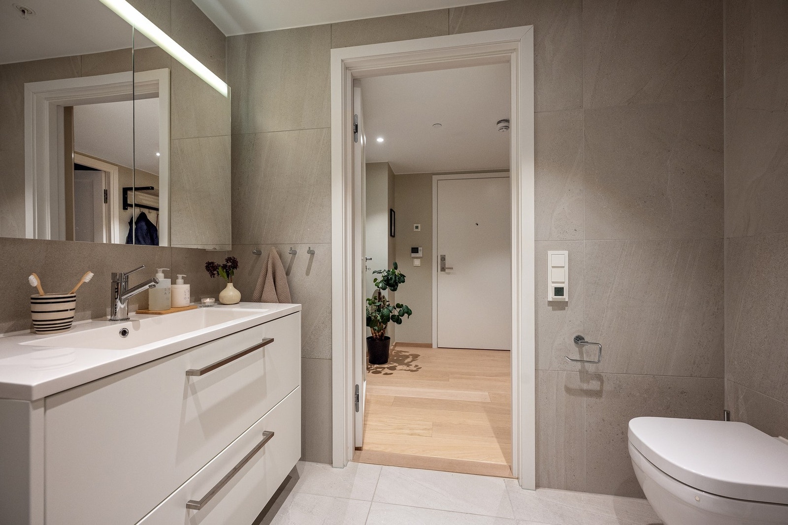 Delikat og romslig baderom med inngang fra entreen Galleribilde