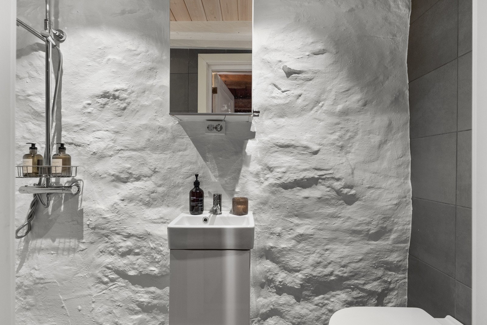 Badet i kjelleren er fra 2022, med bevart original, hvitmalt naturmur. Galleribilde