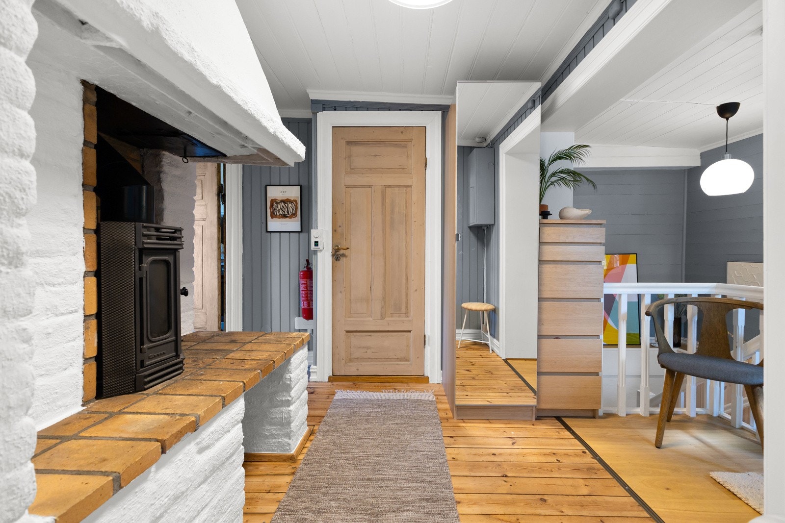 Den romslige gangen inneholder klassisk peiskassett som en av fire ildsteder i boligen. Galleribilde