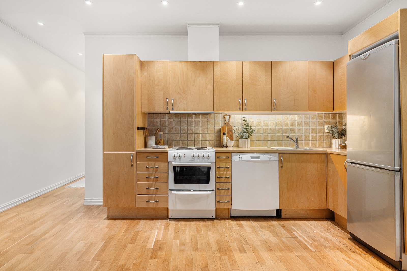 Innredningen har glatte fronter i tre og laminert benkeplate med nedfelt stålkum. Galleribilde