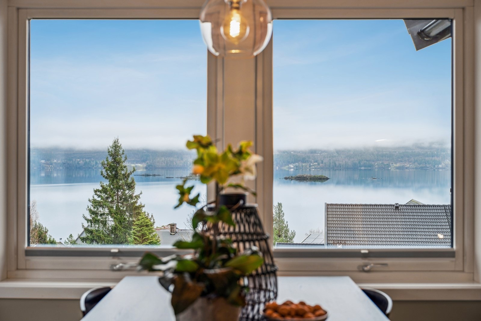 ... Mens du nyter den vakre utsikten over fjorden med skogkledde åser som bakteppe. Galleribilde