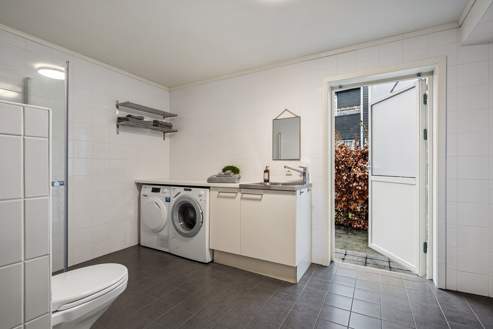 Rommet er utstyrt med vaskeromsinnredning med laminatbenkeplate, utslagsvask i metall og opplegg for vaskemaskin. Galleribilde