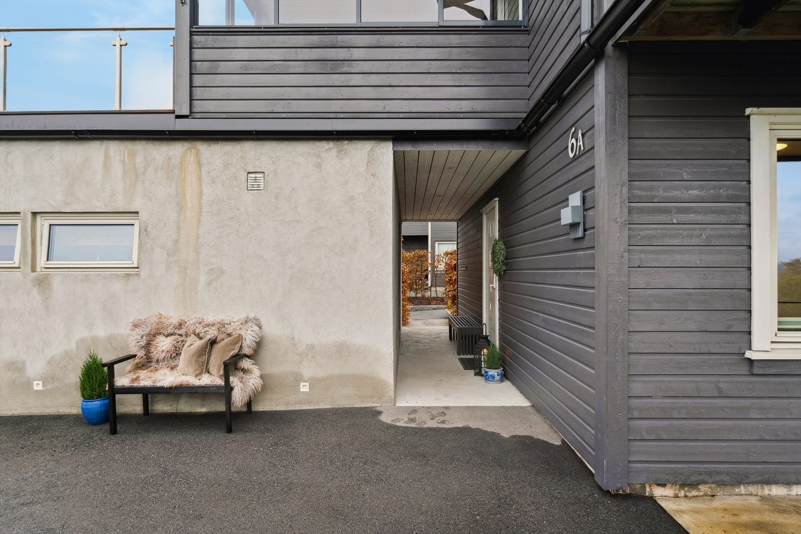 Boligen har adkomst gjennom et overbygget inngangsparti. Skjermer for vær og vind. Galleribilde