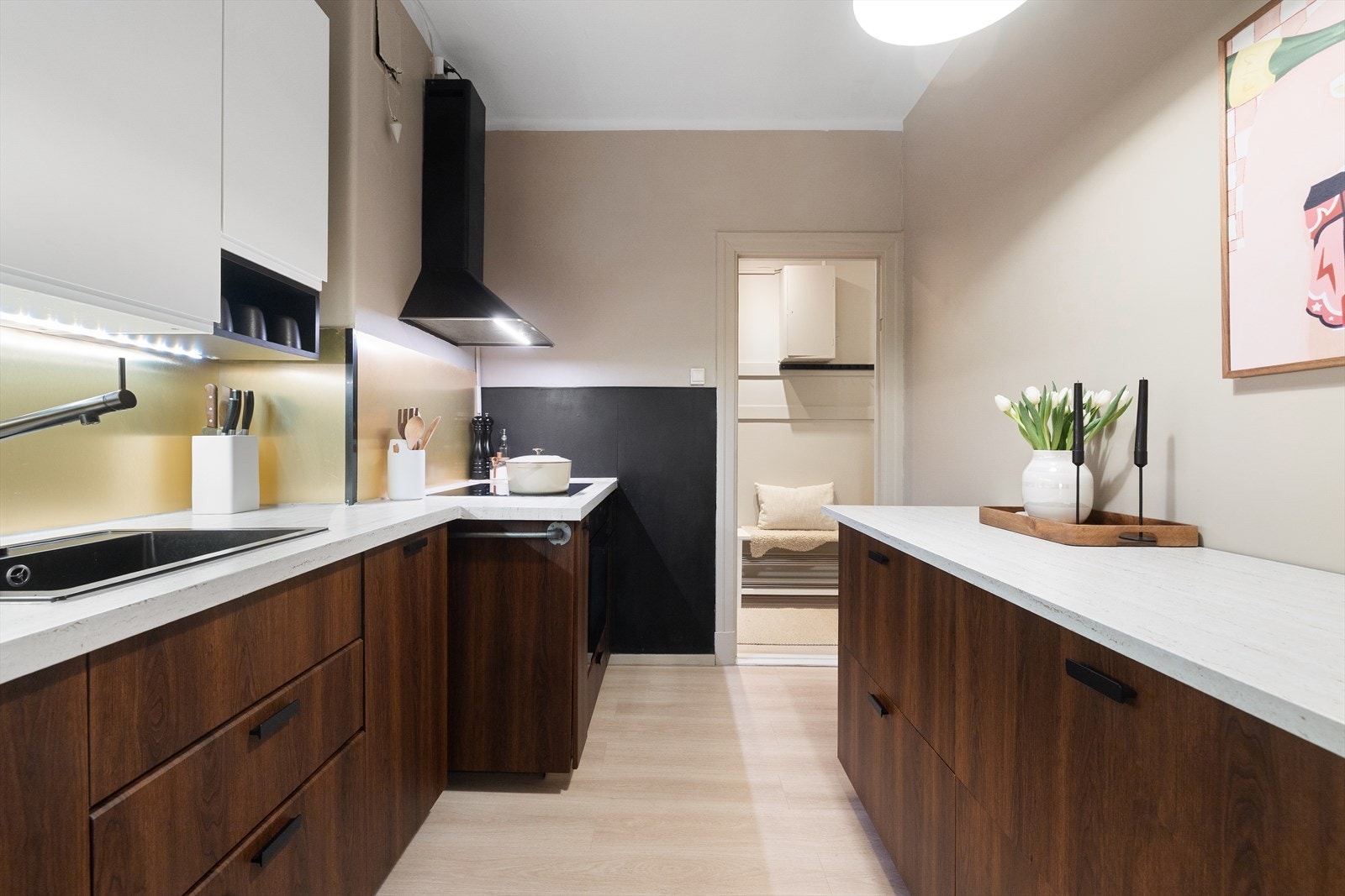 Hvitevarene består av frittstående kjøleskap, kullfiltervifte over integrert koketopp, stekeovn (2025) og integrert oppvaskmaskin. Galleribilde