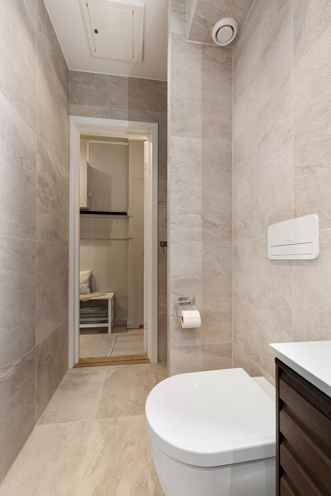 Innredning og garnityr på badet består av veggmontert toalett, dusjplass i nisje og baderomsinnredning med skuffer, servant med ettgreps blandebatteri og speil. Galleribilde