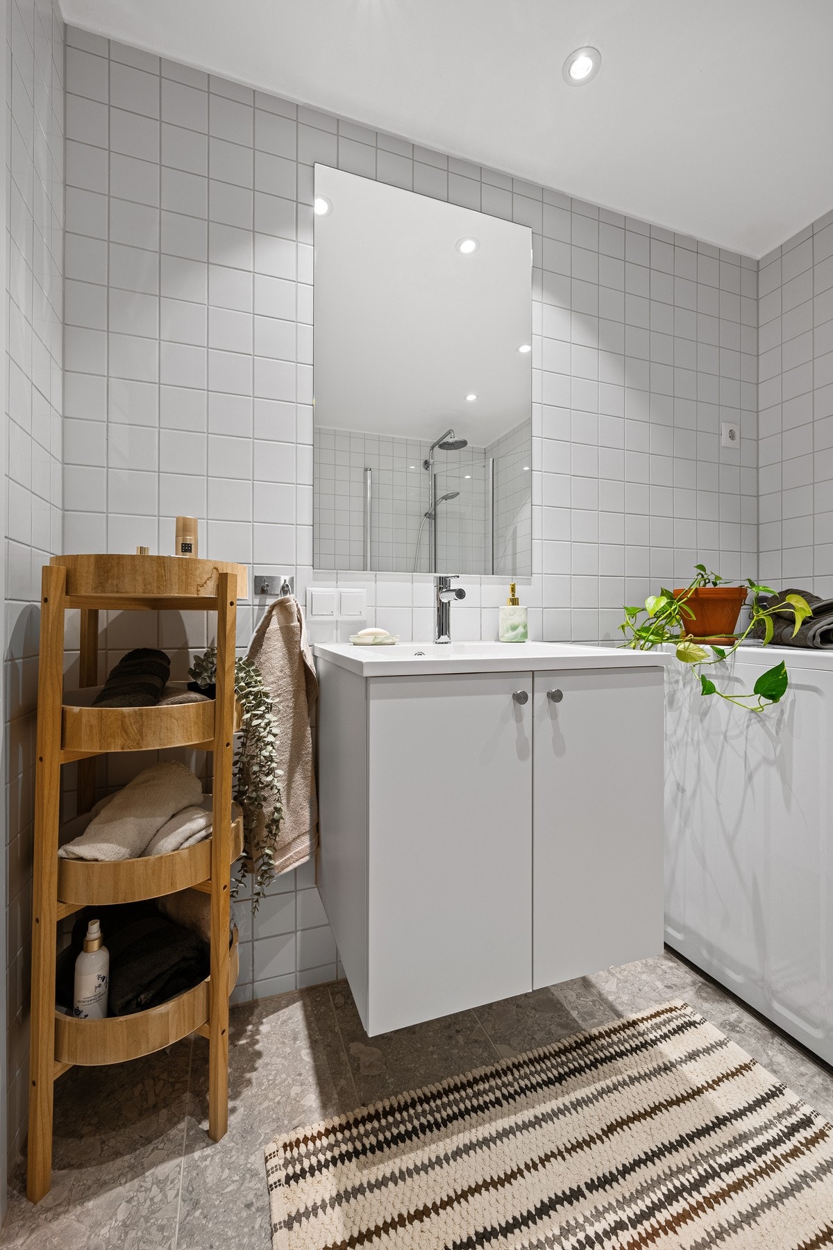 Innredningen består av vegghengt toalett, stilren servant, praktisk dusjnisje og opplegg for vaskemaskin - alt du trenger for en funksjonell baderomsløsning. Galleribilde