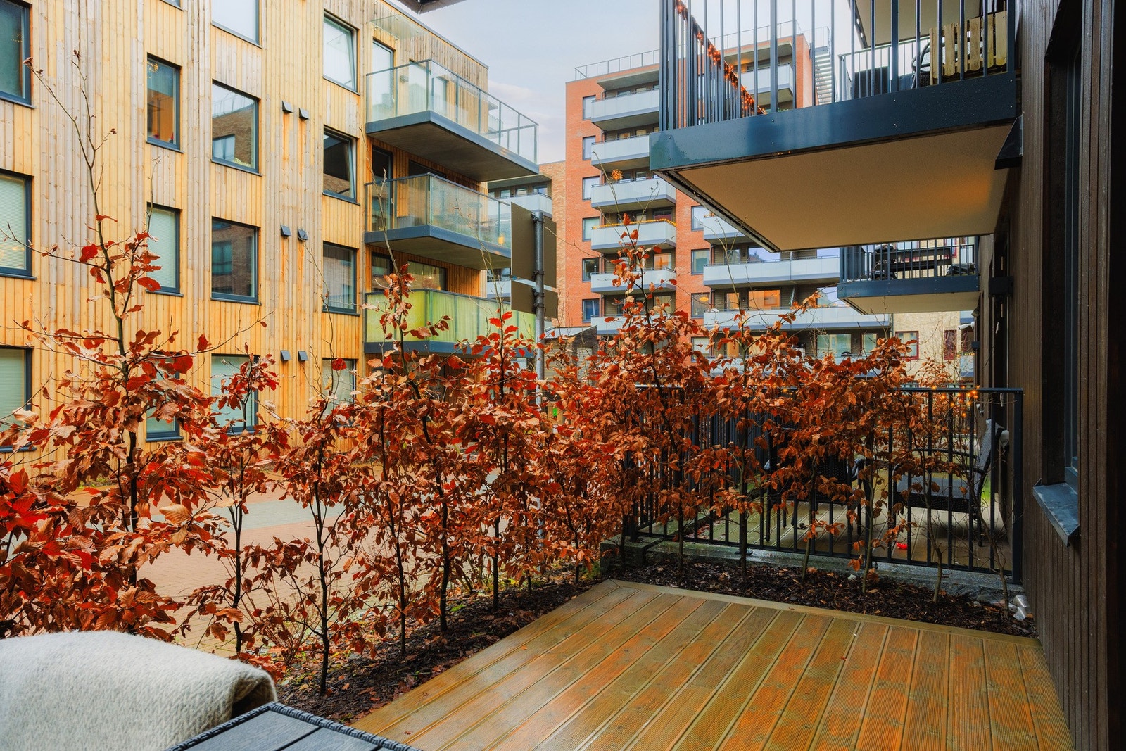 Vestvendt platting på ca. 11 m², pent omkranset av busker som skjermer og gir følelsen av et lunt og frodig uterom, selv i et urbant bomiljø. Galleribilde