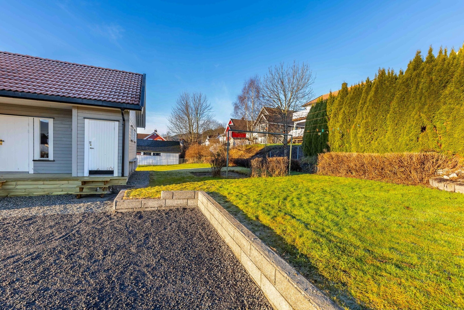 Rett utenfor inngangsdøren er det direkte adkomst til hagen hvor man også har et tørkestativ. Galleribilde