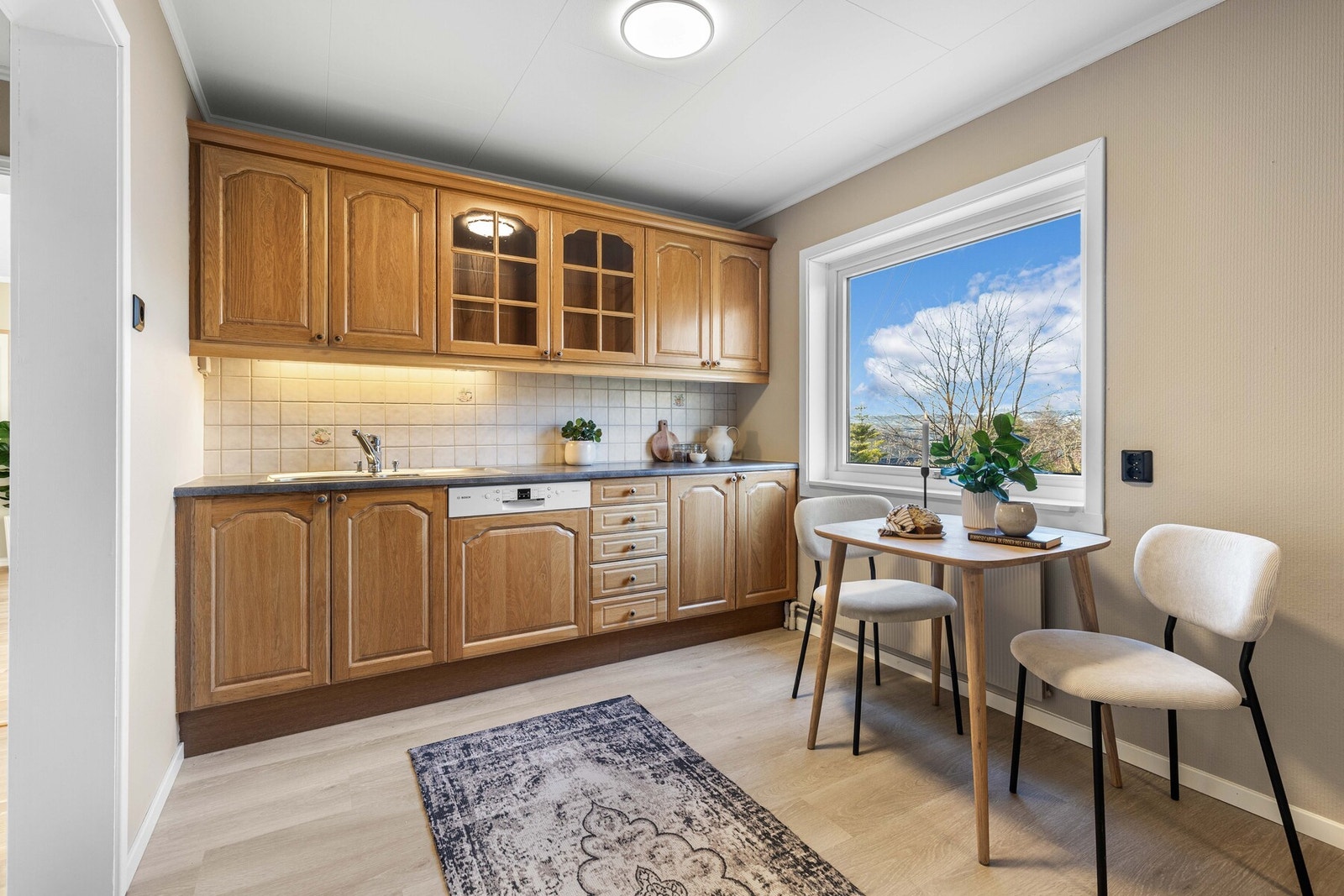 Kjøkkenet er utstyrt med integrert oppvaskmaskin, frittstående komfyr og platetopp, samt nedfelt utslagsvask i benkeplaten. Galleribilde