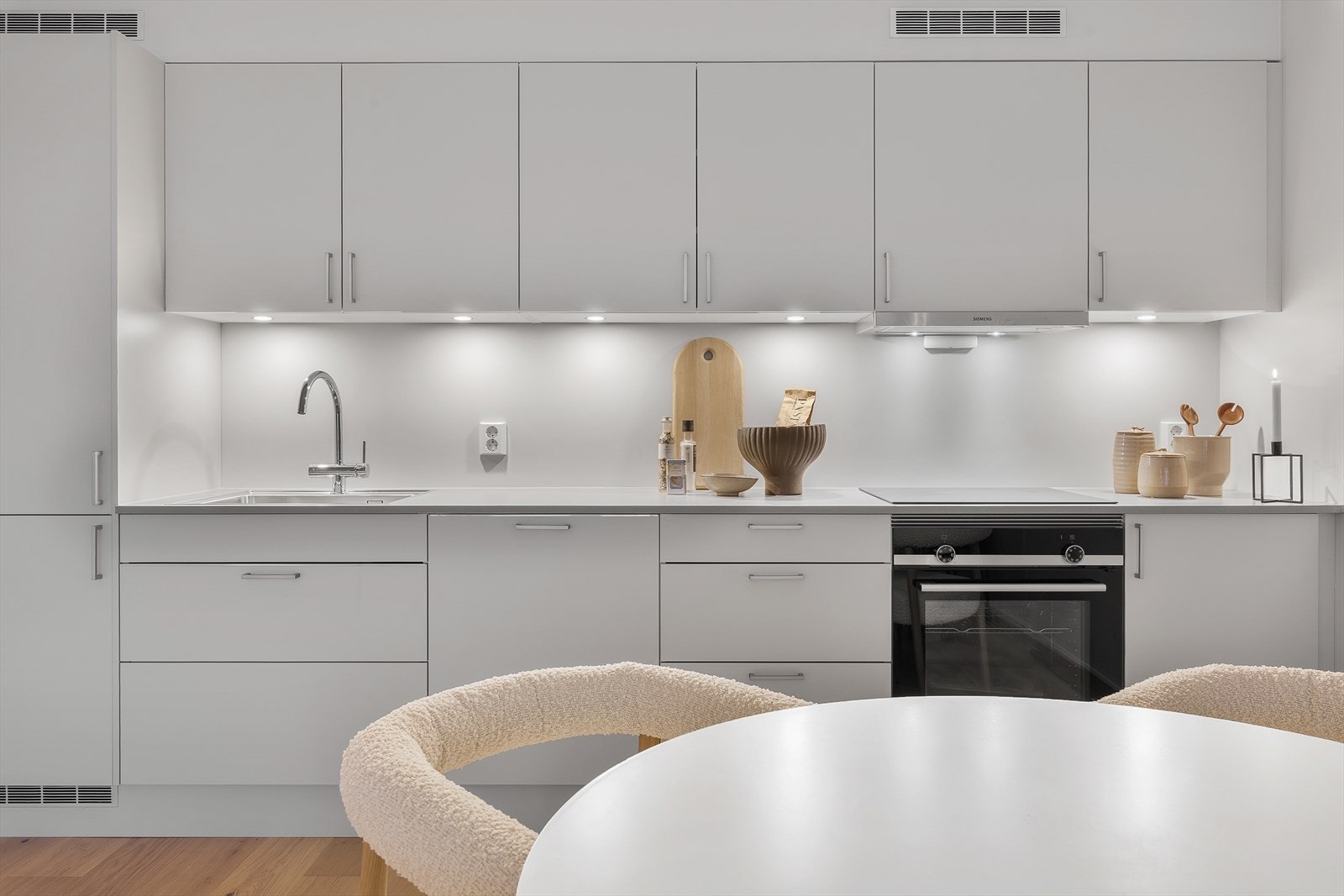 Oversiktlig kjøkken med integrerte hvitevarer, moderne linjer og god benkeplass. Galleribilde