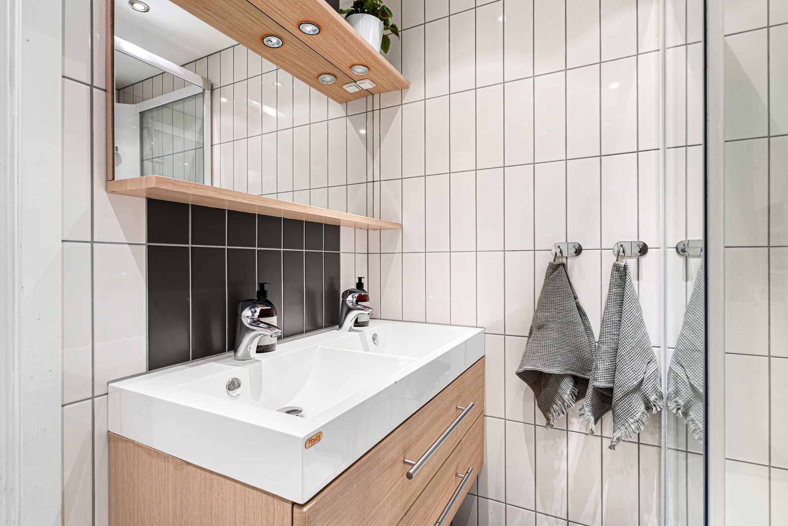 Rommet er utstyrt med servantinnredning, speil med overlys og dusjkabinett. Galleribilde