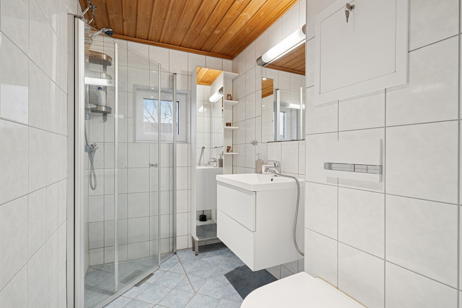 Badet er fra 2013 og har flislagte overflater og varmekabler i gulvet. Galleribilde