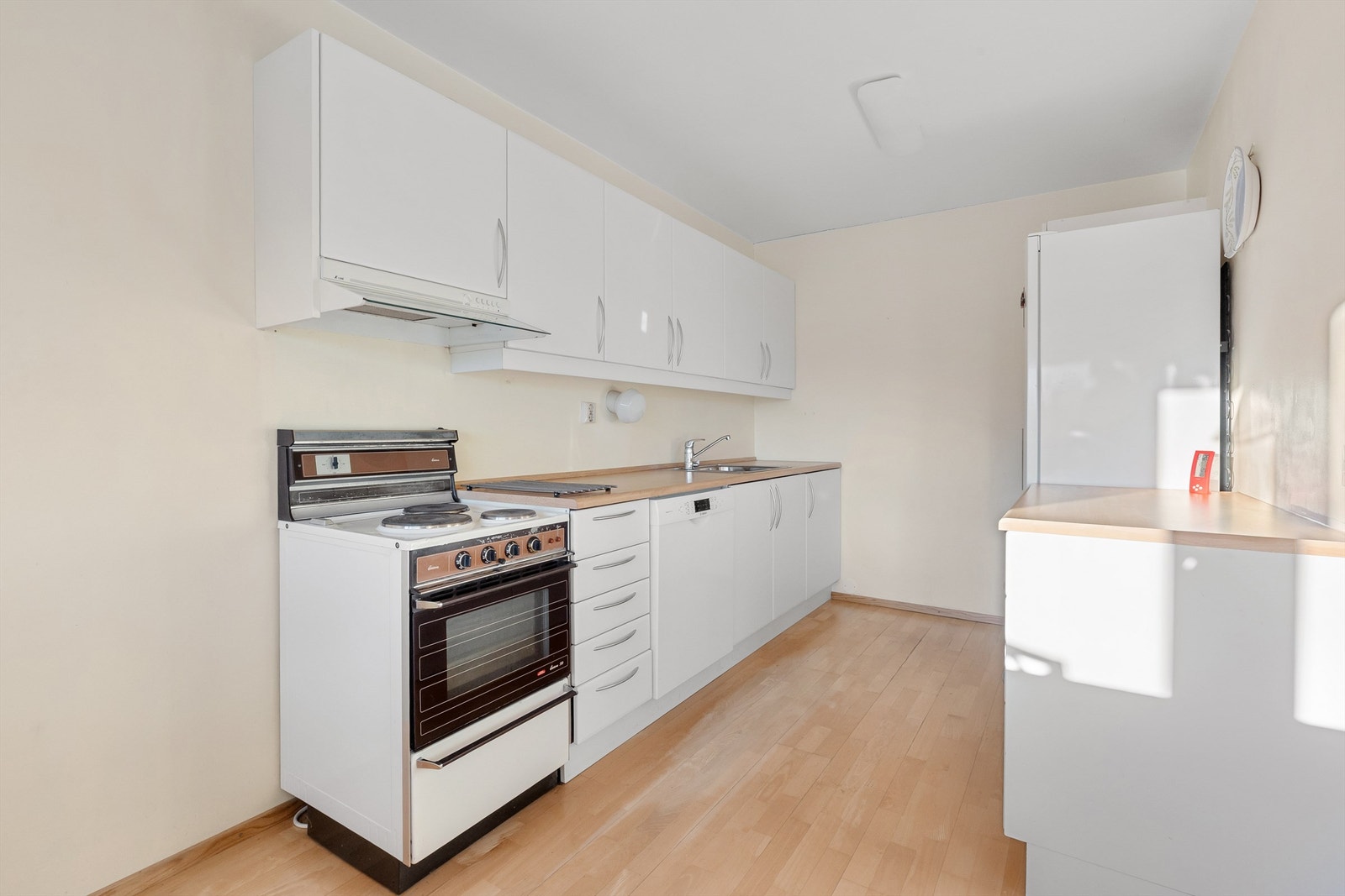 Kjøkkenet har glatte fronter på skap og skuffer, laminert benkeplate med nedsenket oppvaskkum Galleribilde